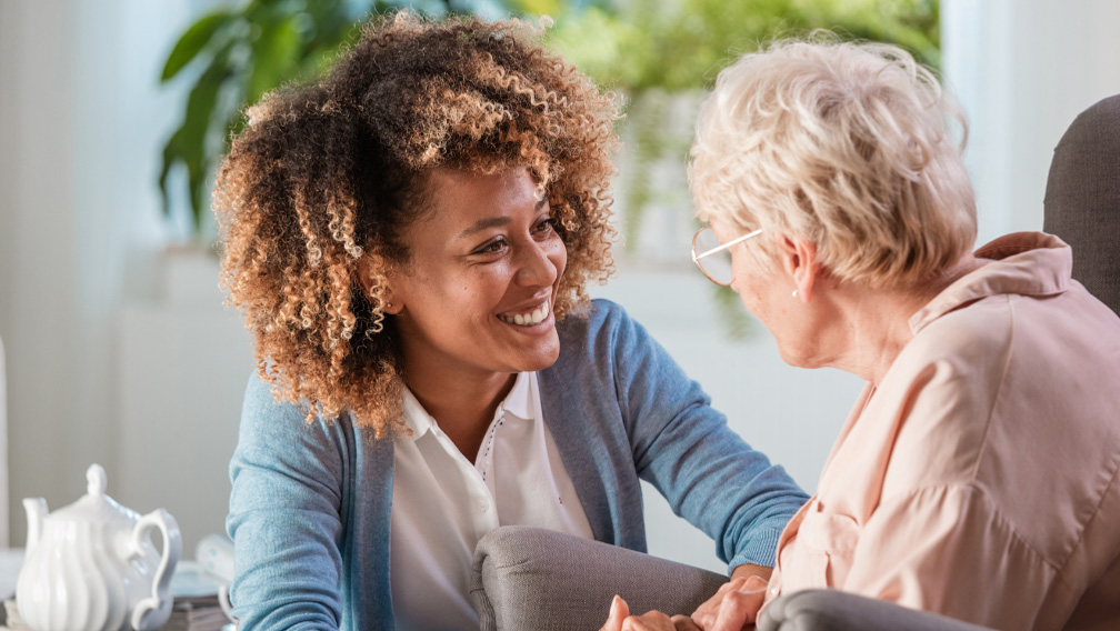 Pflegekraft begleitet ältere Frau mit Demenz im Alltag