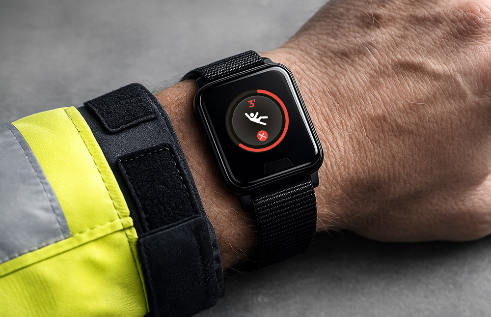 Worker wearing personal safety alarm watch with automatic fall detection feature