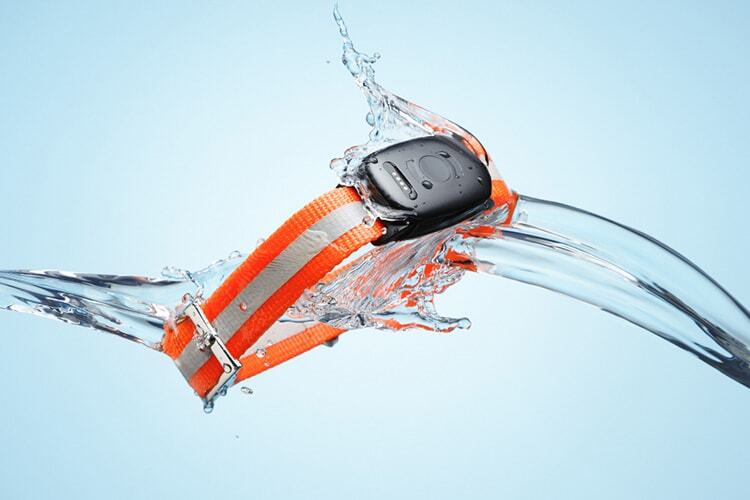 MiniFinder Atto Pro splashed with water. Light blue background and bright orange collar to the Atto Pro.