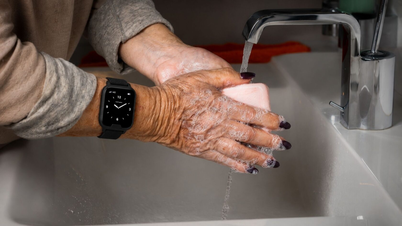 Senior wearing a water-resistant safety watch while washing hands