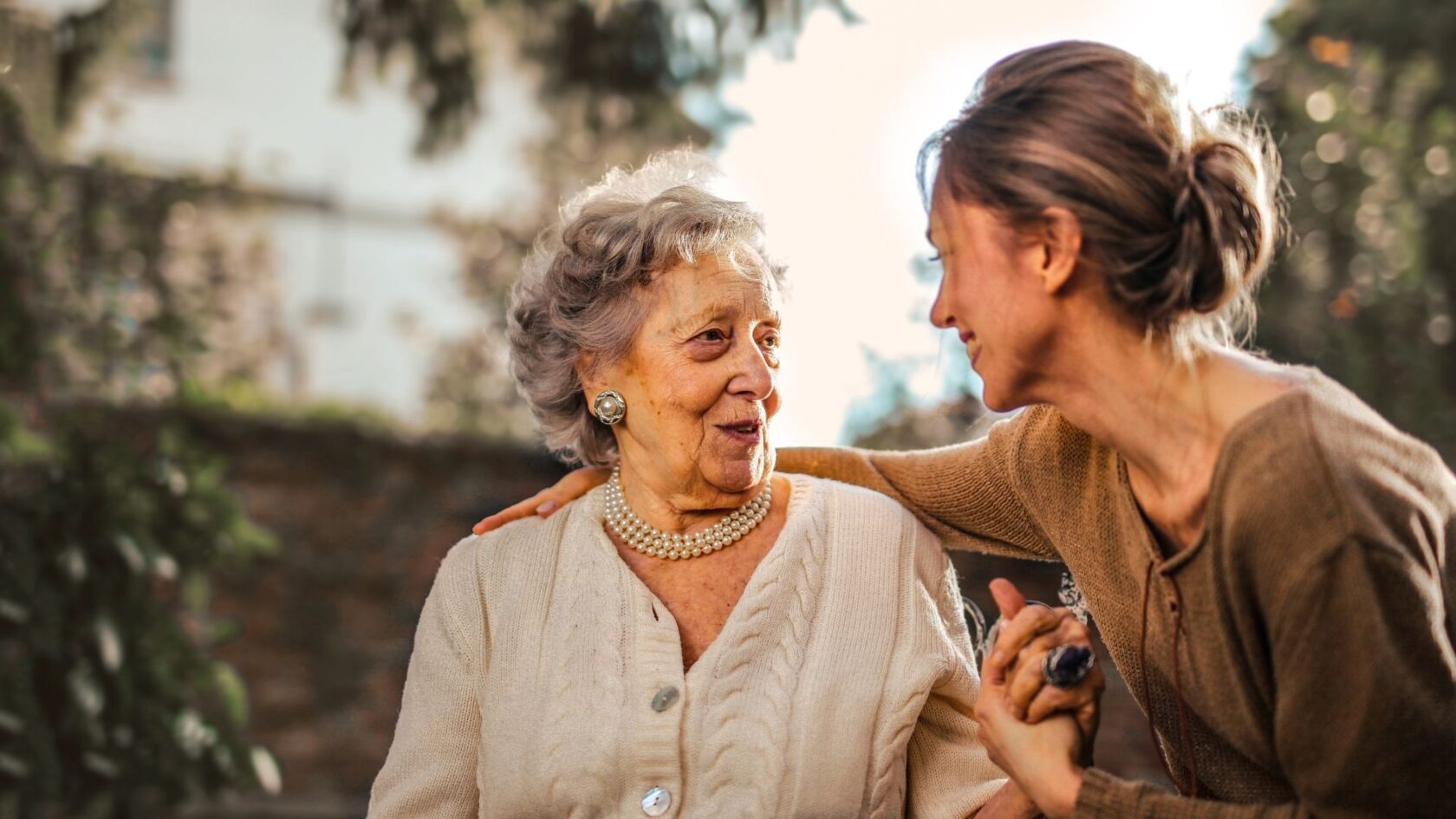 Adult daughter talking with her elderly mother at home