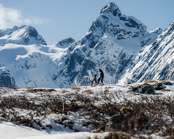 Dog with Atto Pro on collar and owner. Walking in snowy mountains